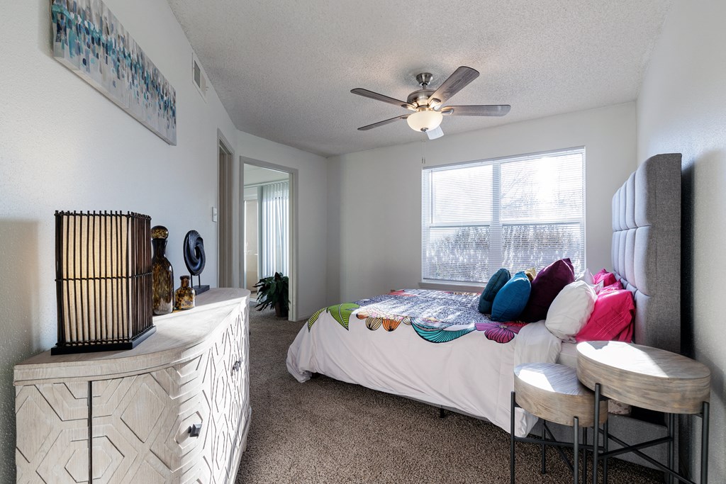 a bedroom with a bed and a ceiling fan