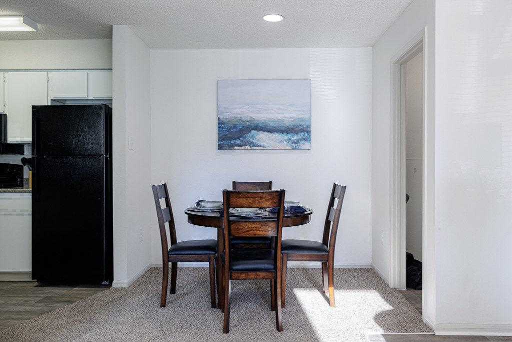 a dining room with a table and chairs and a painting on the wall