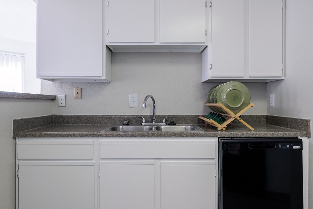 a kitchen with white cabinets and a sink