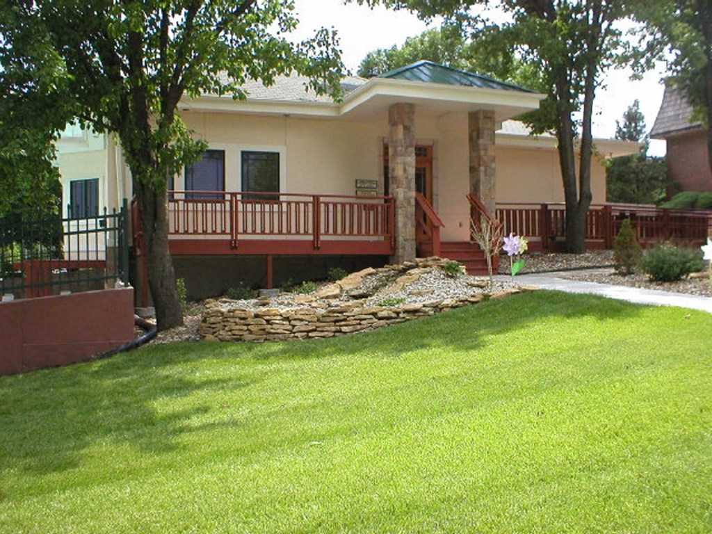 The exterior of the Cedar Ridge Apartments clubhouse with green grass in the foreground.