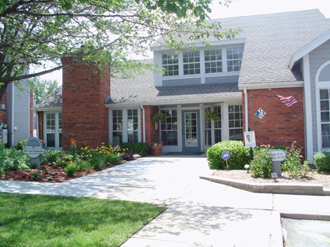 the front of a house with a driveway and a flag