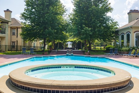 A sparkling swimming pool with the Enclave at Town Center clubhouse in the background.