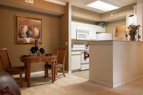 Dining and kitchen area at Enclave at Town Center featuring cabinetry, appliances, and space for dining.