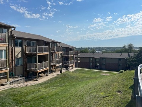A row of apartment buildings with a grassy area in the foreground.