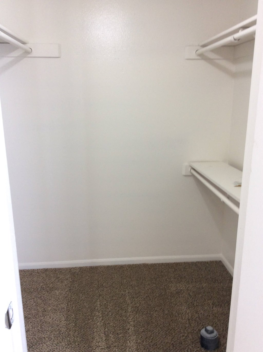 Master bedroom closet in the Yeakel Townhome, featuring a carpeted floor and a shelf for storage.