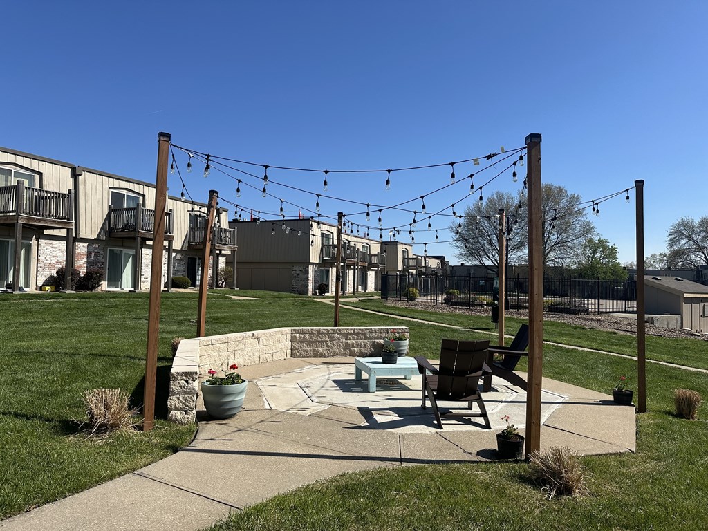 A garden with a fire pit in front of an apartment building, offering a cozy outdoor space.