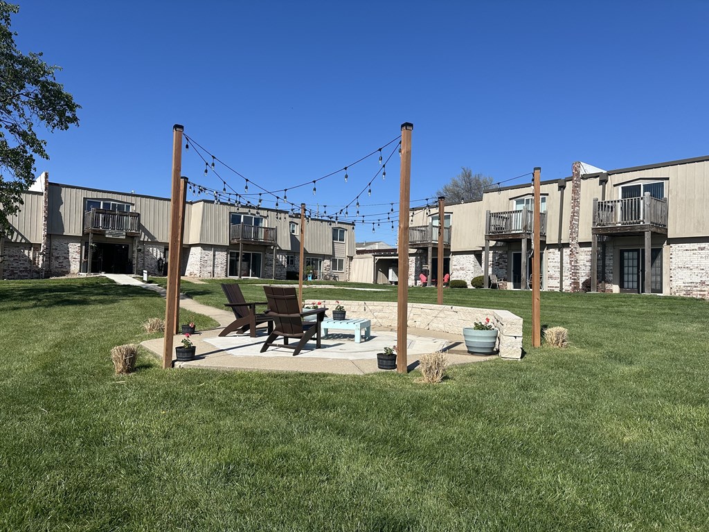 Patio area at Park 25 Apartments, featuring a fire pit in front of the apartment building, creating a cozy gathering space.