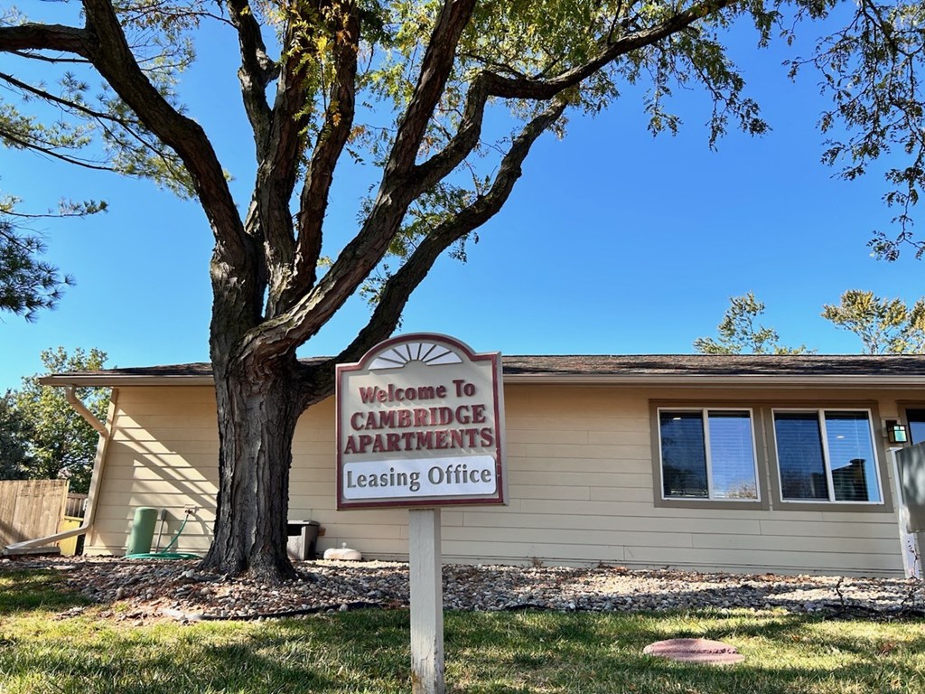 Leasing office sign at Cambridge Apartments that reads 'Welcome to Cambridge Apartments Leasing Office' in front of the building.