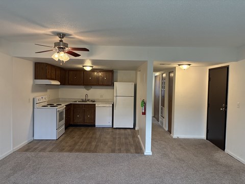 Vacant apartment kitchen at Park 25 Apartments featuring cabinets, refrigerator, and stove.
