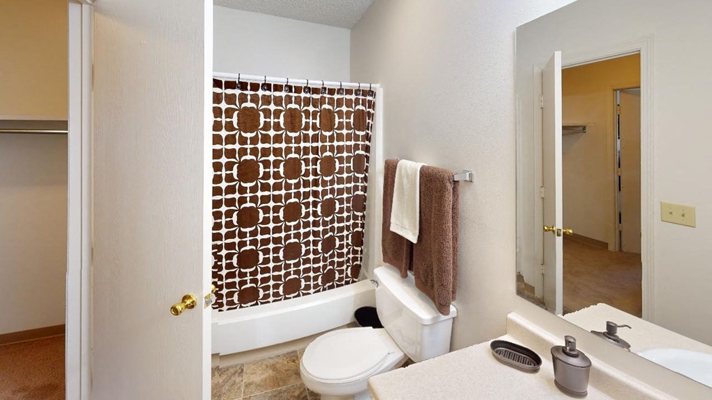 a bathroom with a white toilet sitting next to a bathtub