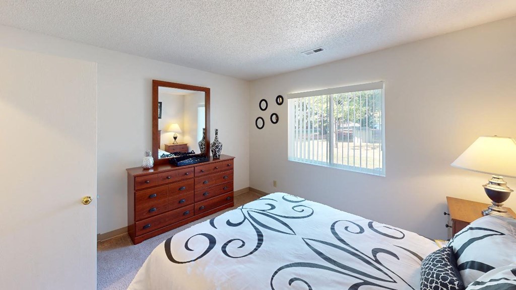 a bedroom with a large bed next to a window