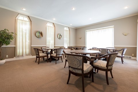 A dining room with a table and chairs.