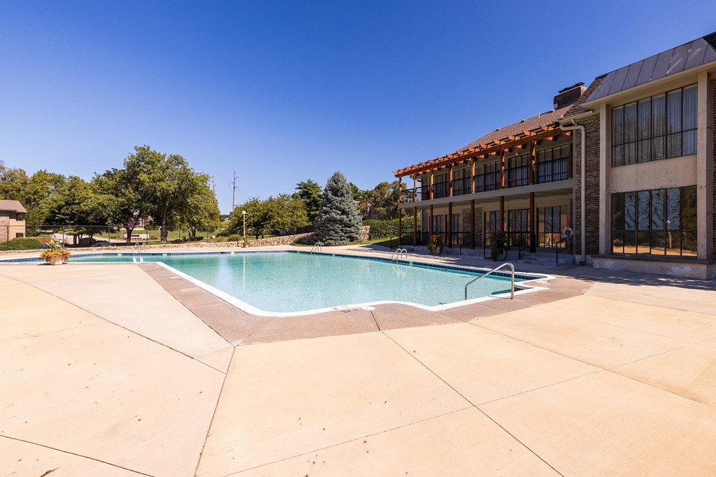 A refreshing swimming pool at Regent’s Walk Apartment Homes, surrounded by lounge chairs and greenery.