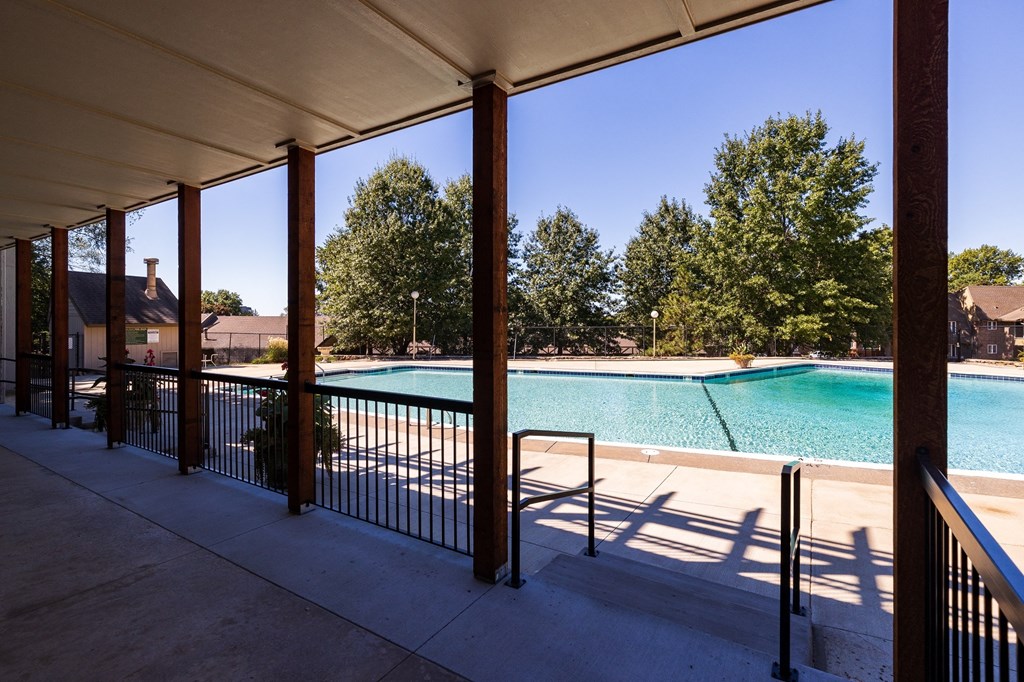 A refreshing swimming pool at Regent’s Walk Apartment Homes, surrounded by lounge chairs and greenery.