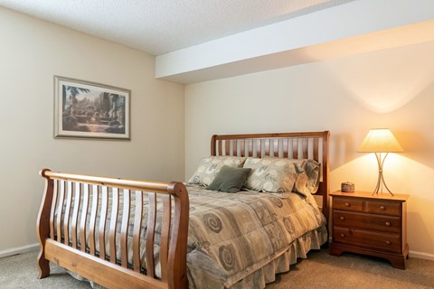 a bedroom with a bed and a nightstand with a lamp