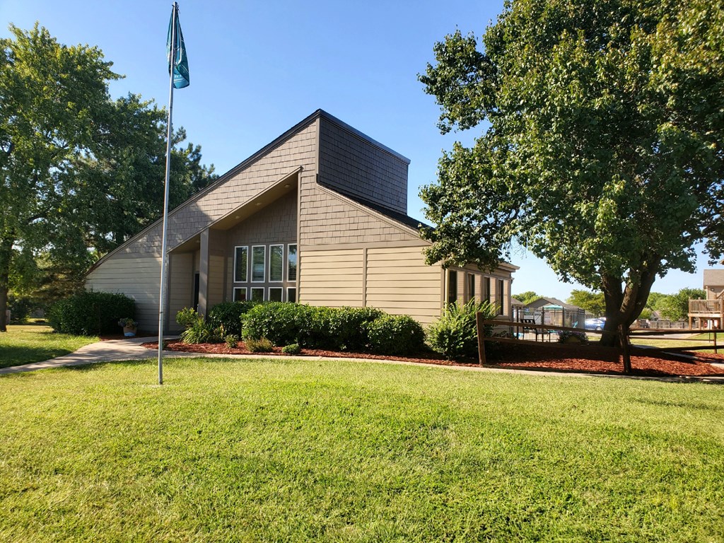 Willow Creek Apartments - Exterior view of the clubhouse with lush landscaping.