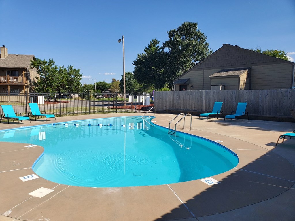 A swimming pool surrounded by lounge chairs, offers a relaxing environment at Willow Creek Apartments.