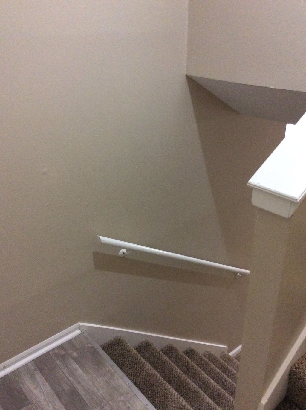 A stairway leading to the upper level of the Yeakel Townhome, with a white handrail.