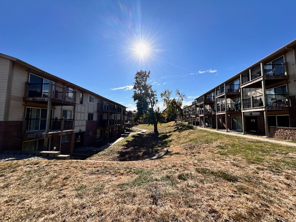 Exterior view of a Cambridge Apartments building on a sunny day, showcasing the building's architecture and surrounding environment.