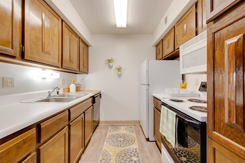 a kitchen with white appliances and wooden cabinets
