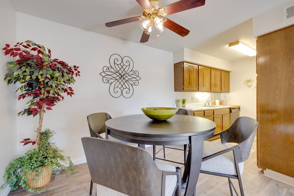 Olde English Village Model Unit - Two Bedroom Dining area in the two-bedroom model unit at Olde English Village, with the kitchen visible in the background.