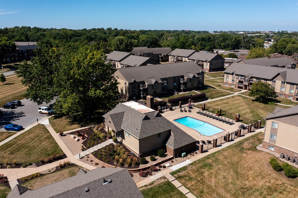 Olde English Village - Aerial View An aerial view of Olde English Village Apartments, nestled among the serene landscape, featuring a cluster of well-maintained buildings with courtyards and walkways.