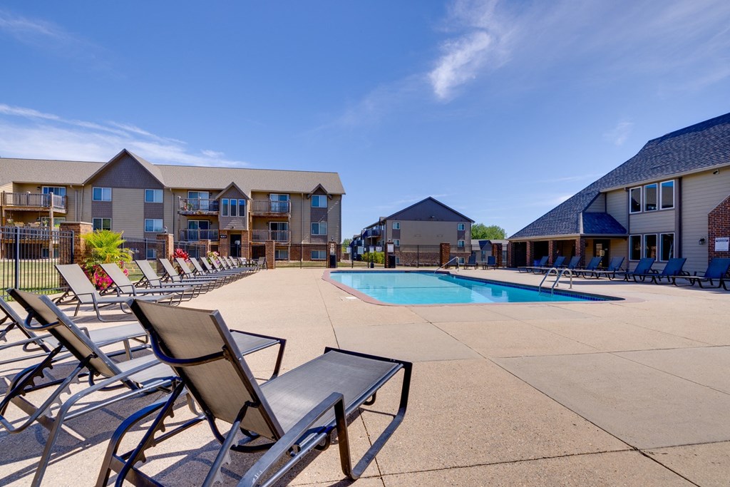 A sparkling outdoor pool at the clubhouse, with clear blue water and sun loungers, invites residents to relax, swim, and enjoy leisurely moments in a beautiful, serene setting.
