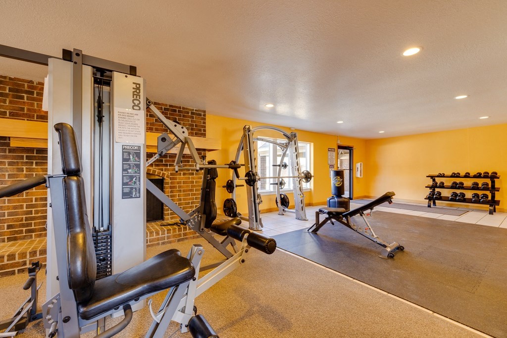 A well-equipped gym with various exercise machines, free weights, and cardio equipment, providing a motivating environment for fitness enthusiasts to pursue their workout goals.
