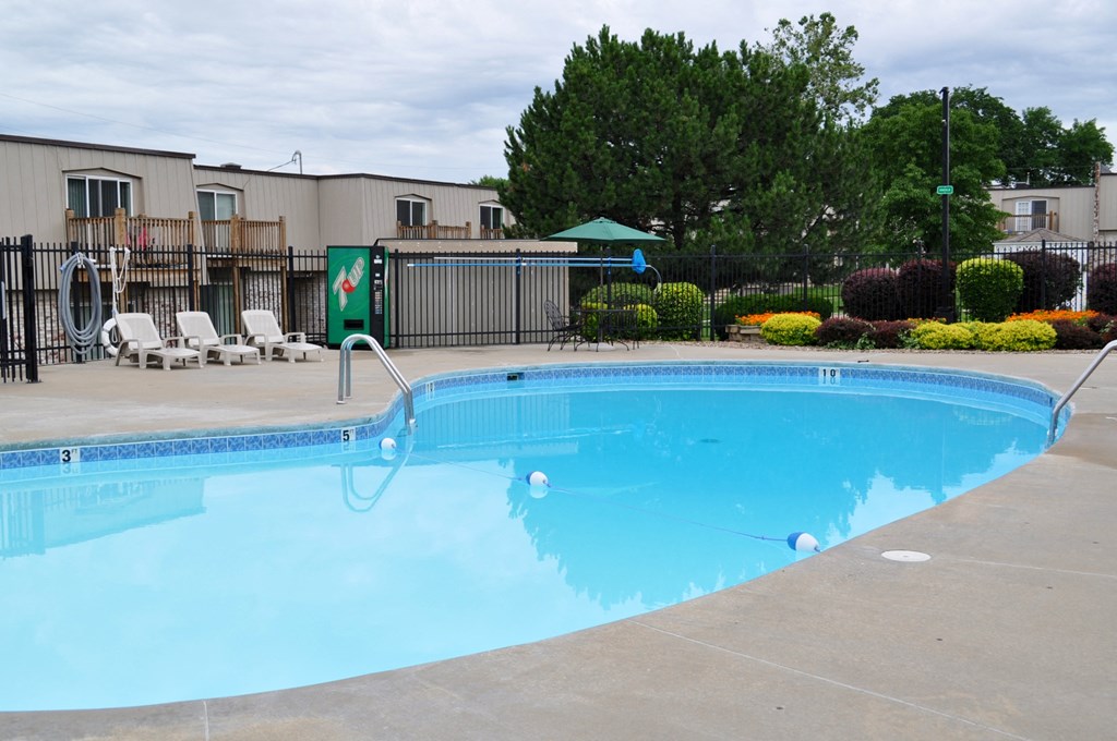 The pool at Park 25 Apartments, featuring calm water, lounge chairs, and a serene environment.