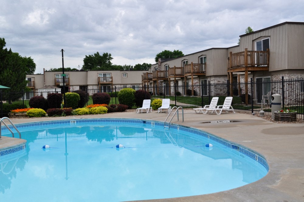 Poolside area with lounge chairs and shaded spots at Park 25 Apartments, providing a relaxing outdoor space.