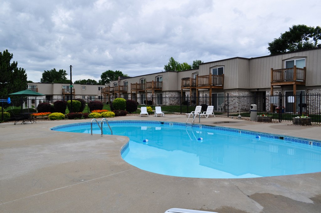 A pool area at Park 25 Apartments, with lounge chairs and clear water, providing a relaxing space.