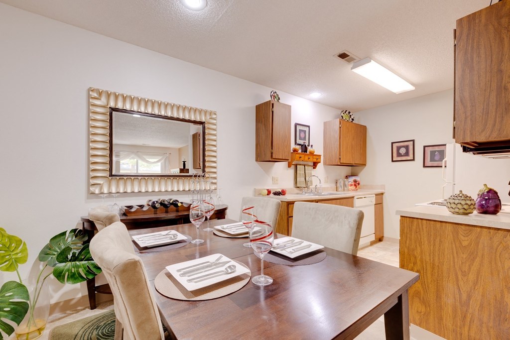 a dining room table in a living room with a kitchen