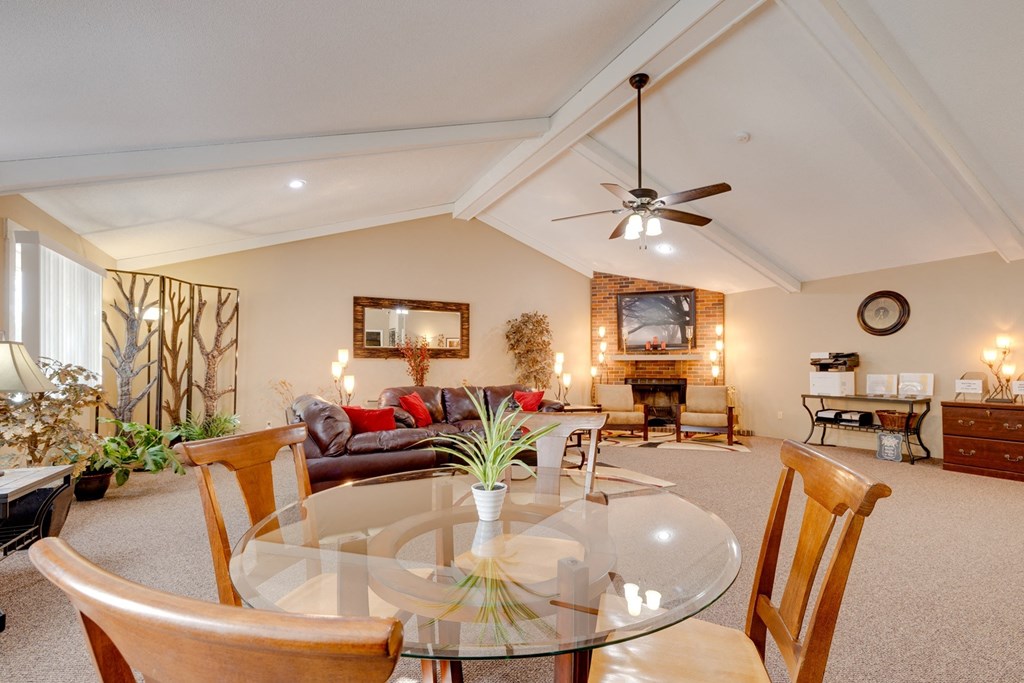 a living room with a glass table and a ceiling fan