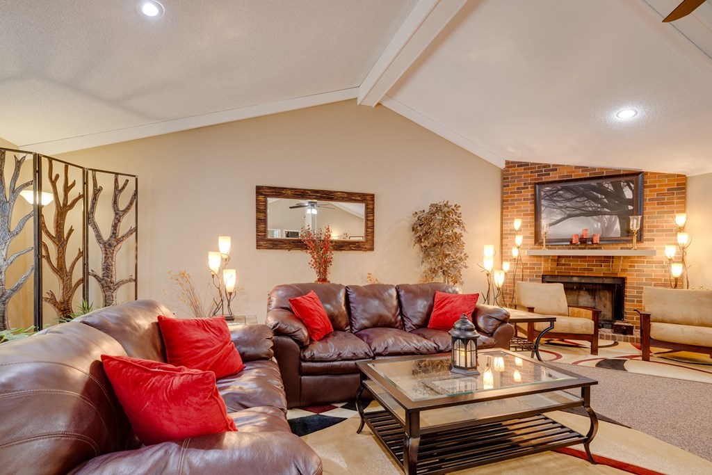 Regency Woods Clubhouse living room with a brown leather sofa and a glass coffee table.