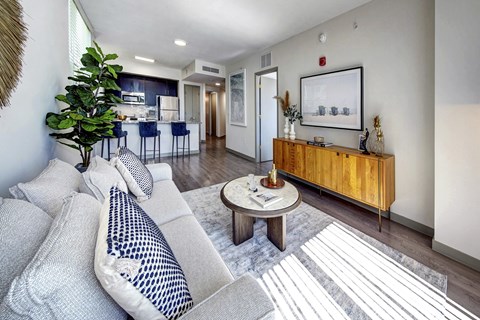 A living room with a grey couch and a wooden cabinet.