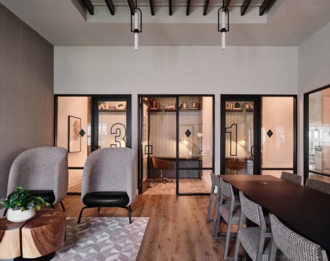 A modern dining room with a long table and chairs.