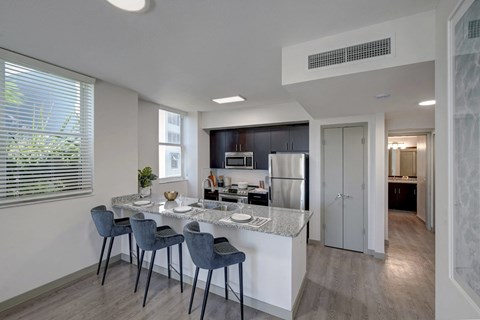 A kitchen with a table and chairs.