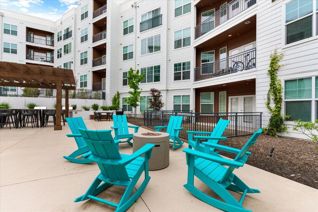 a patio with blue chairs and a fire pit at the bradley braddock road station