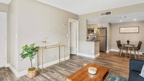 A living room with a blue couch and a wooden coffee table.