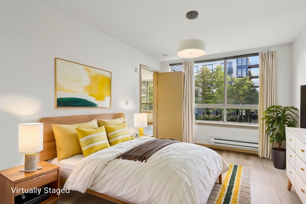 A bedroom with a large bed and a painting on the wall.