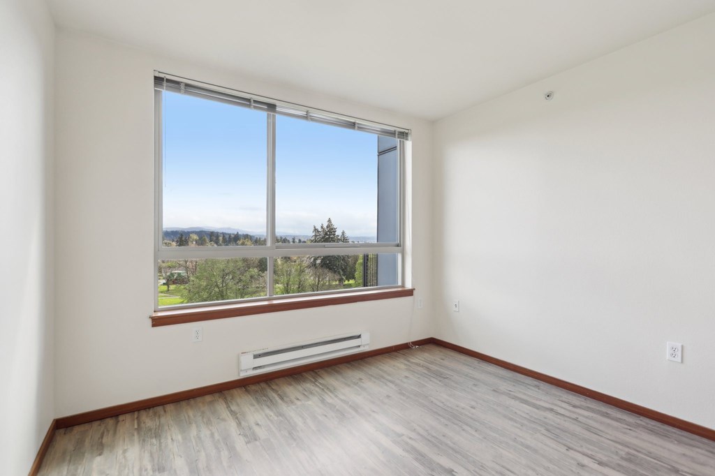 A room with a large window overlooking a landscape.