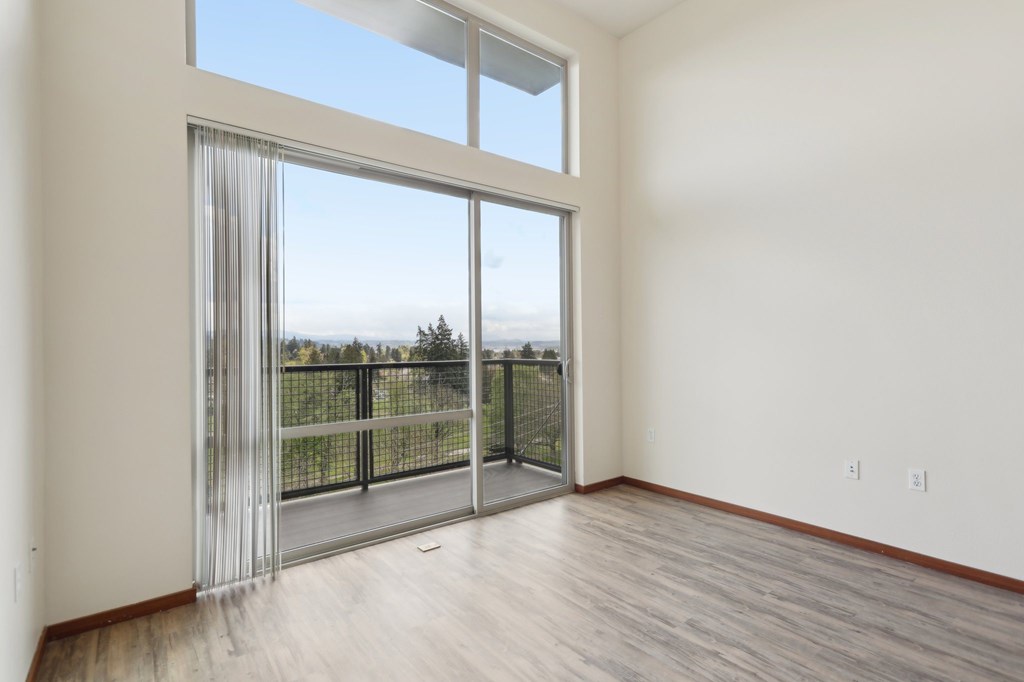 A room with a sliding glass door leading to a balcony.