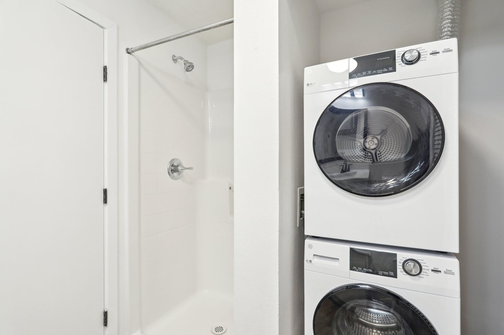 A white washing machine is placed next to a white door.