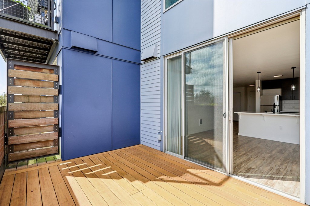 A blue wall with a wooden deck in front.