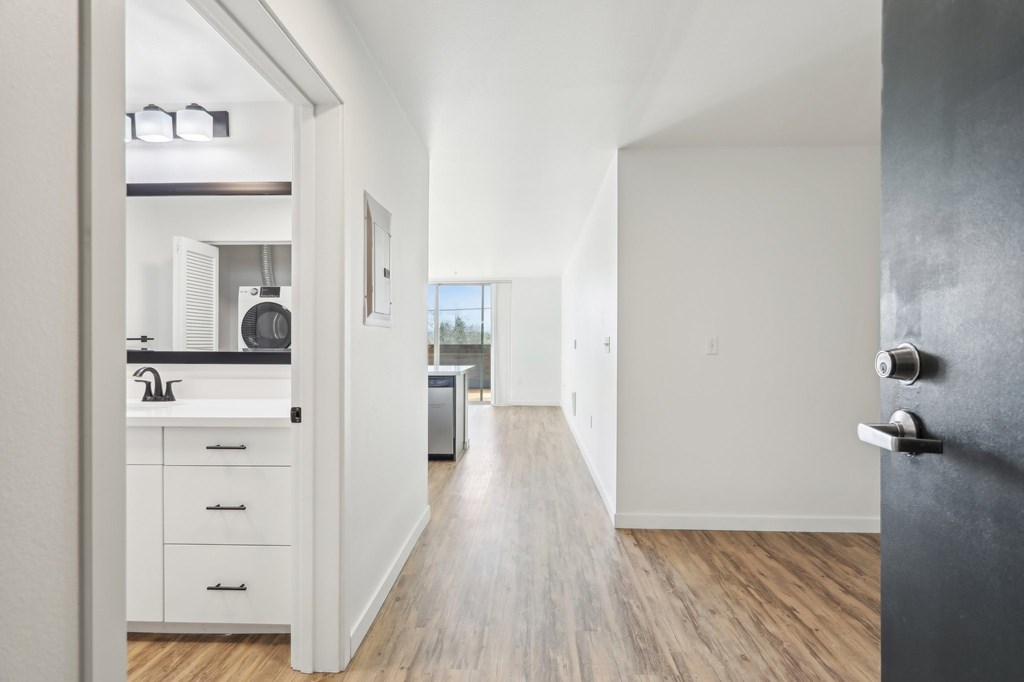 A kitchen with white cabinets and a black refrigerator.