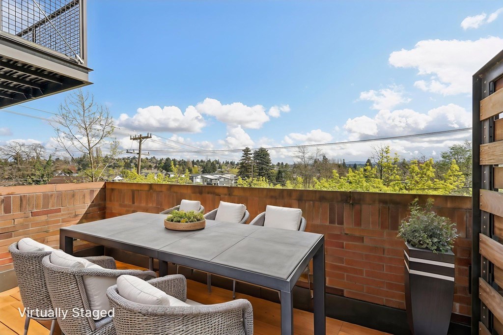 A patio with a table and chairs overlooking a landscape.