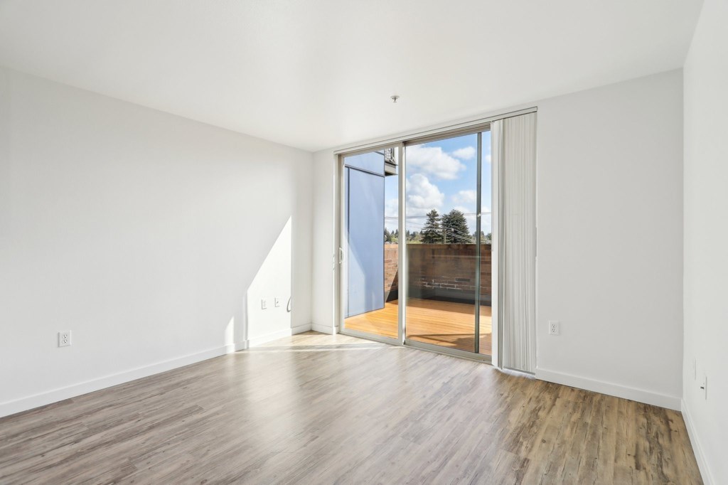 A room with a sliding glass door leading to a balcony.