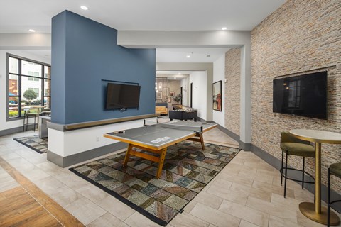 a living room with a ping pong table and a television