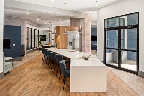 a large kitchen with a large island and a long table with chairs