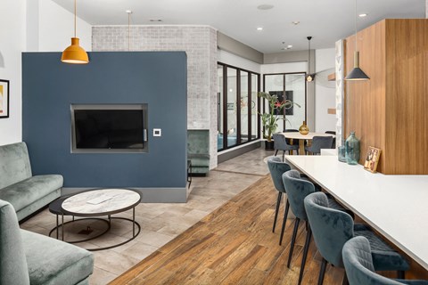 a living room with a blue accent wall and a long table with chairs